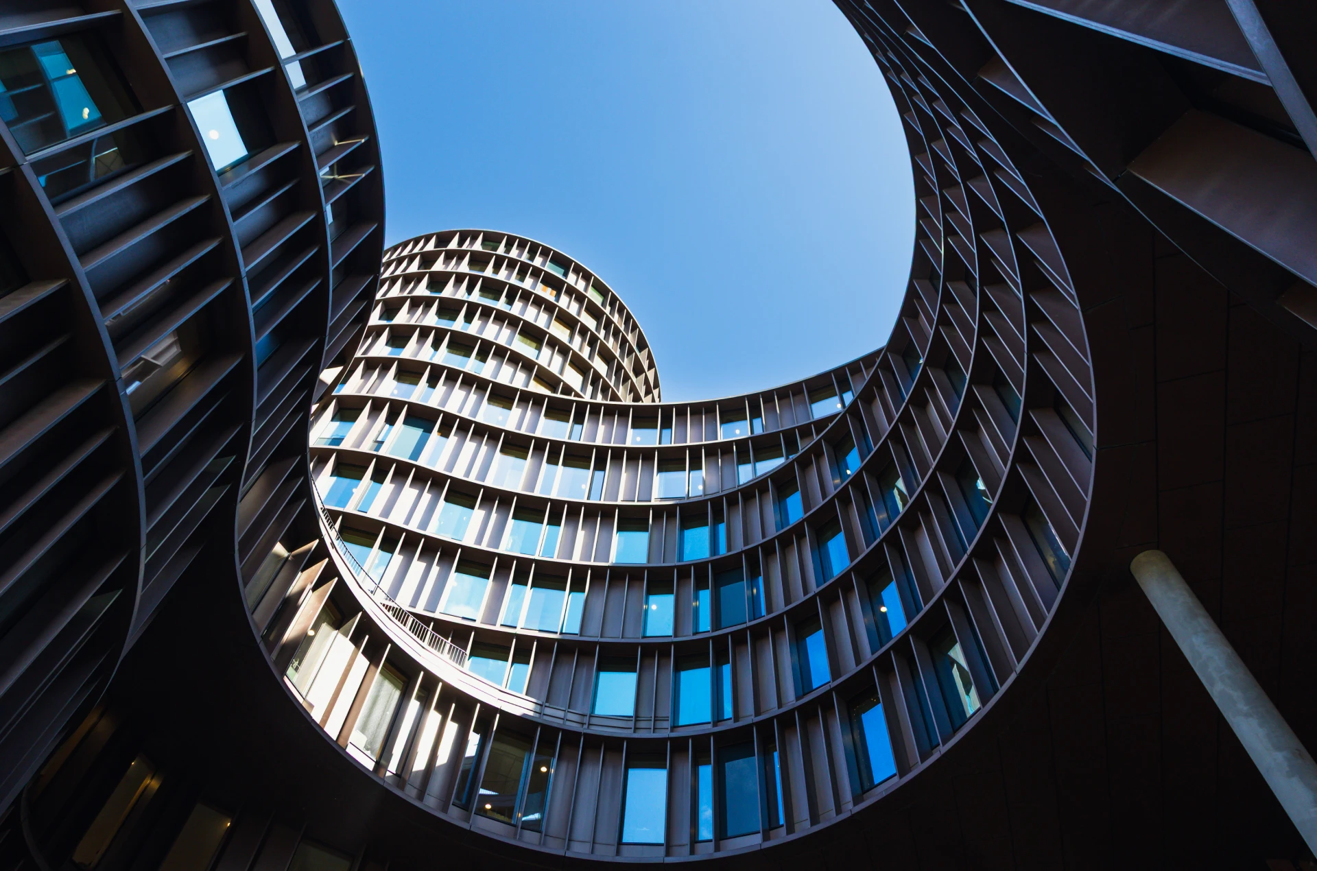 Curved modern building with blue sky.